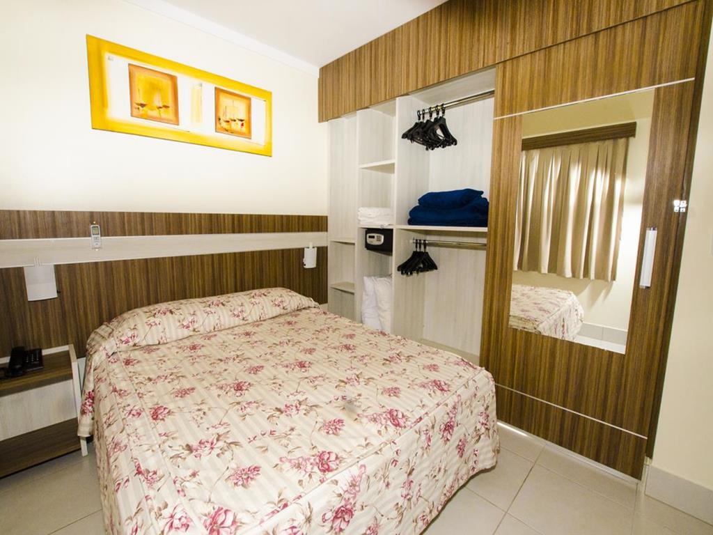 Quarto do Lacqua diRoma II, ao centro cama de casal decorada com toalhas e a direita guarda-roupa com cofre e espelho.