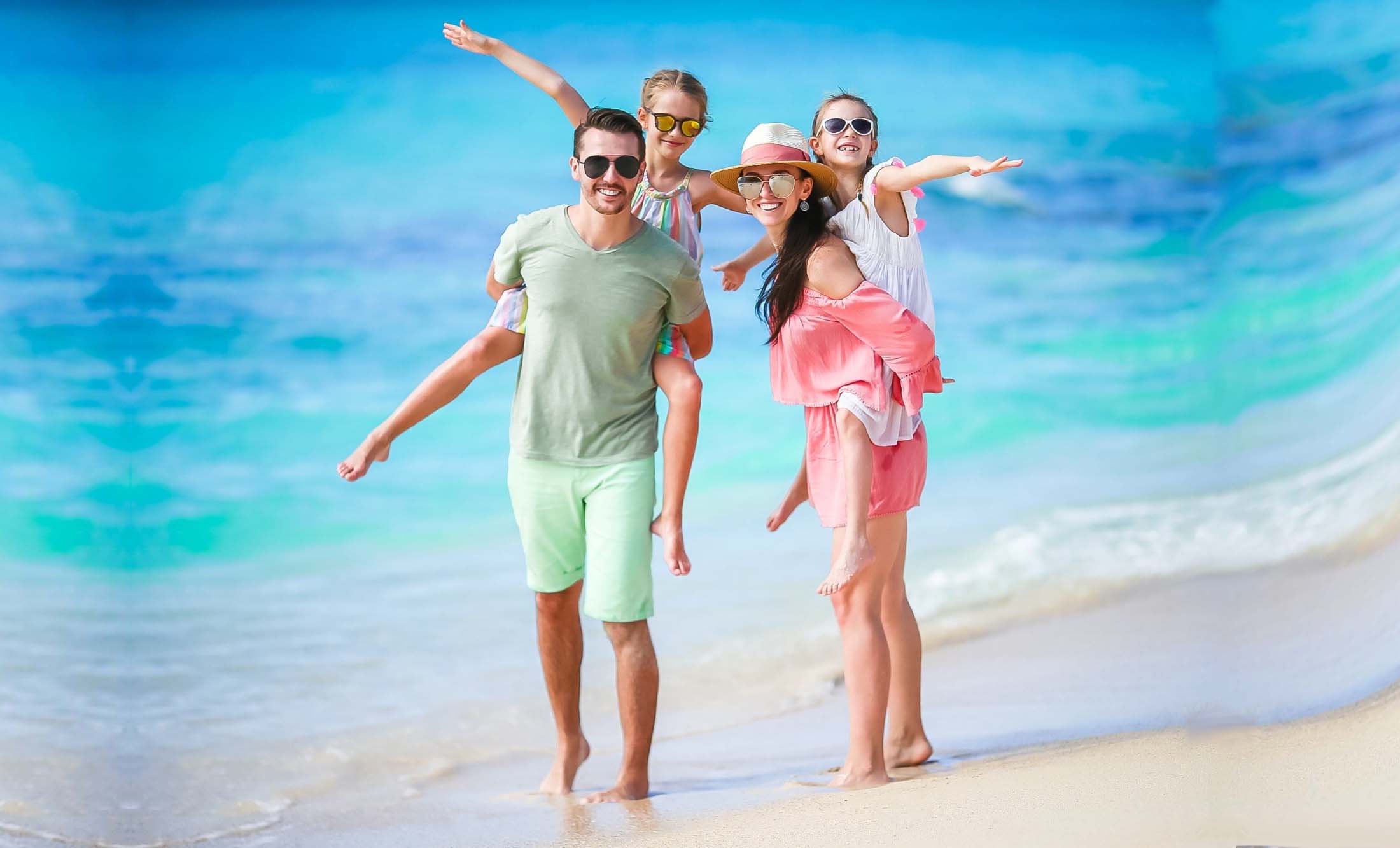 Imagem aérea do mar raso e seus corais sob a água cristalina, barcos e banhistas aproveitam o dia ensolarado